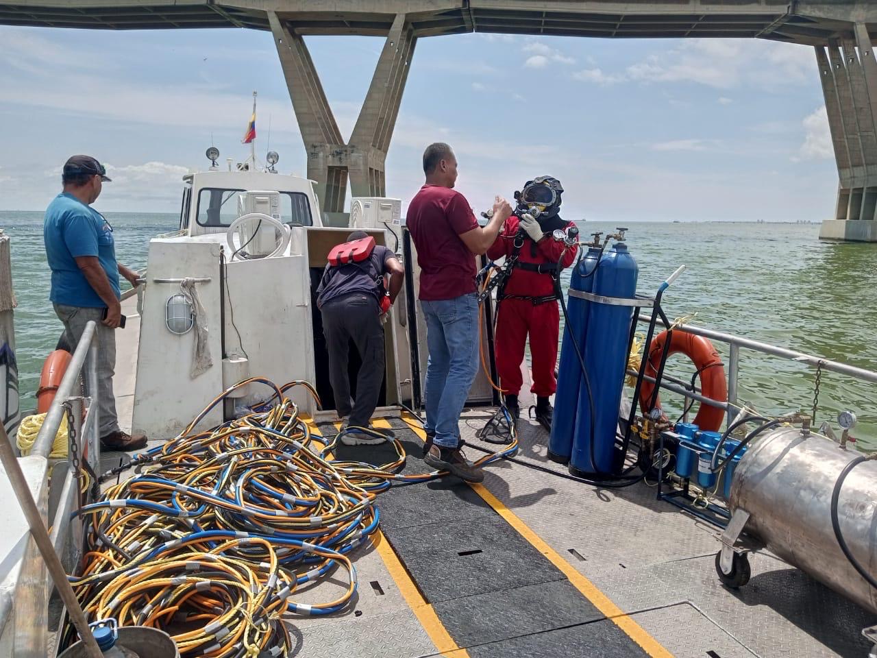 Dive team setting up air supply equipment on vessel deck