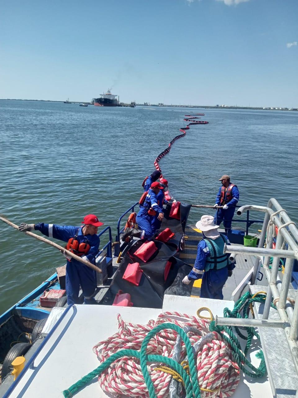 Crew conducting waterborne survey and boom deployment from vessel